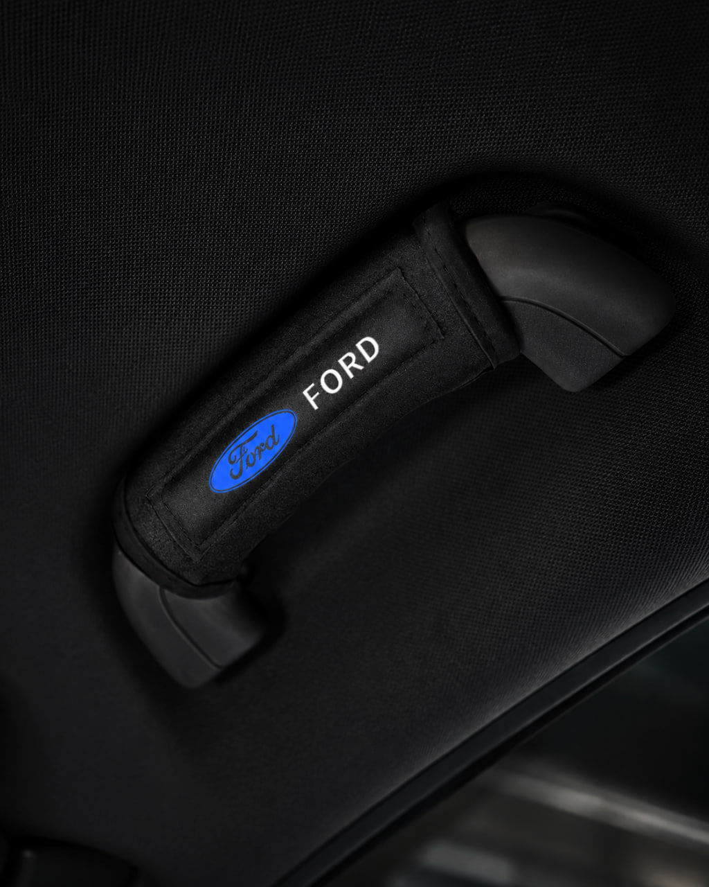 Branded grab handle cover installed on a vehicle interior handle