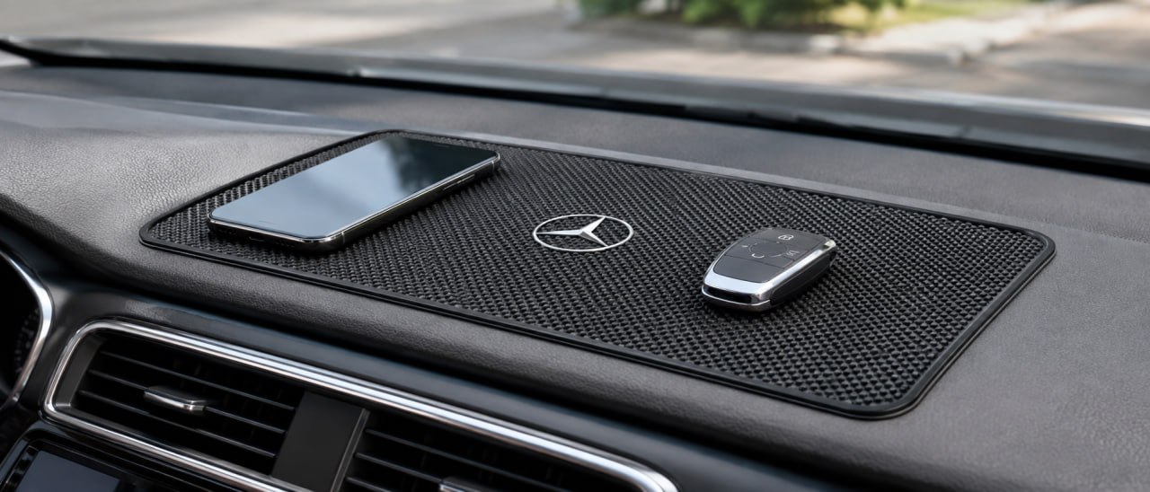 Anti-slip dashboard mat holding a phone and key fob in place