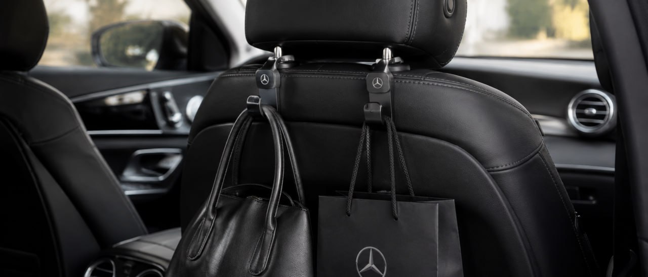 Headrest hooks holding a handbag and shopping bag behind the front seat